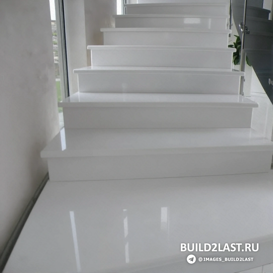 Лестница из мрамора с колоннами и коваными перилами, в бежевых и коричневых оттенках, украшенная элементами дикого камня.